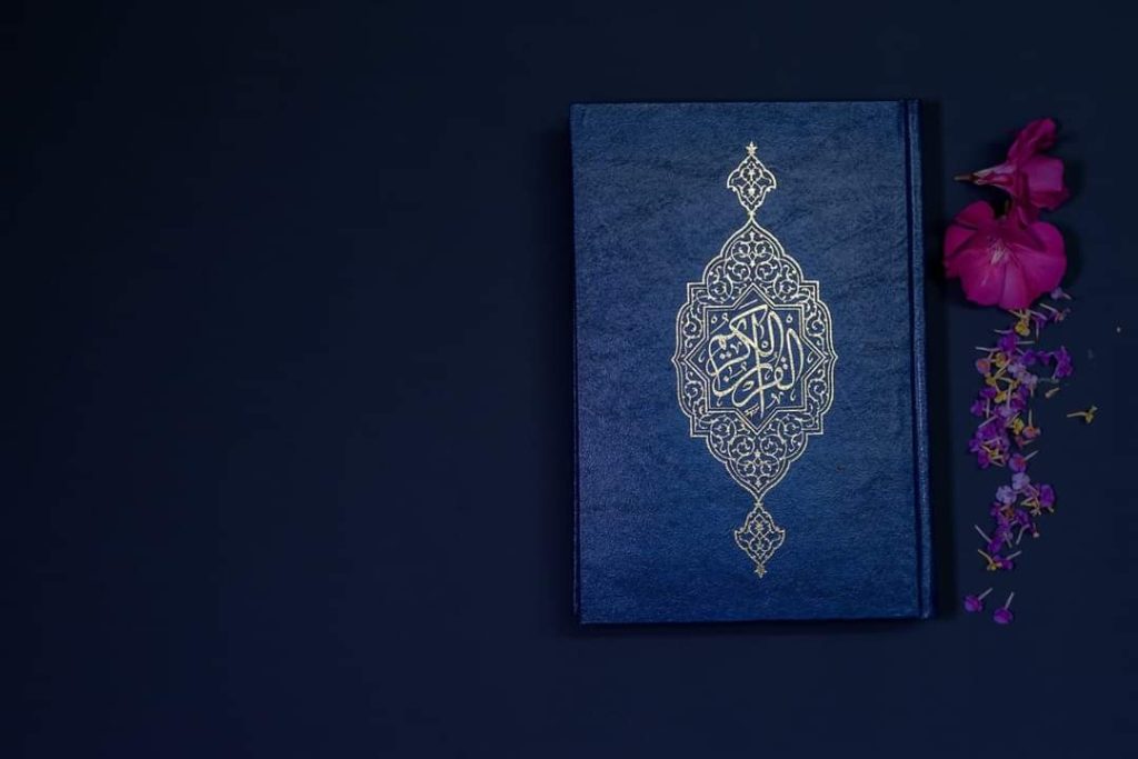 A copy of the Quran beside some flowers