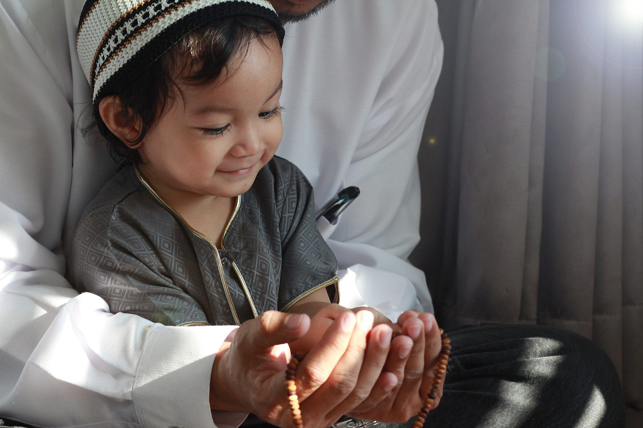 |A child reading Quran pointing out the Ayah