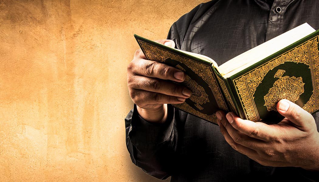 |A man reading Quran in darkness with a deep concentration|The greatest divine book